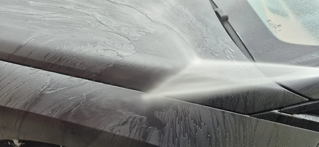 Chemicals being rinsed off BMW iX M70 bonnet